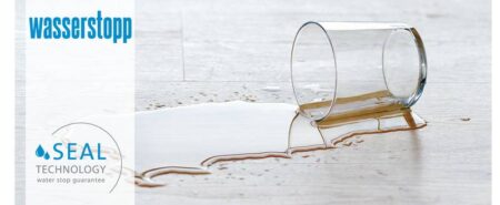 Et glas er væltet. Vand på gulvet